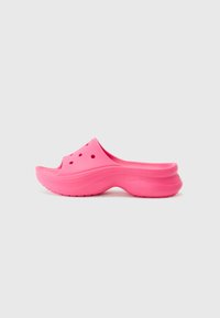 Sabot en plastique rose avec dos ouvert, présentant des trous de ventilation sur le dessus et une semelle épaisse et courbée pour un meilleur soutien.