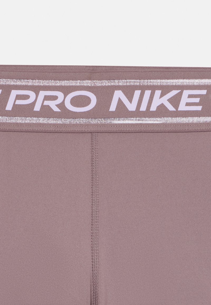 Leggings Pro Nike in un delicato colore mauve con una cintura larga che presenta il nome del marchio in bianco. Texture morbida con cuciture visibili.