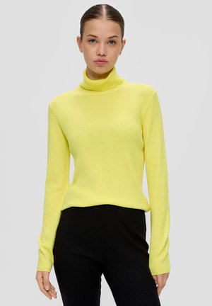 Helles, gelbes, geripptes Rollkragensweatshirt mit langen Ärmeln, kombiniert mit schwarzen, gerippten Hosen, vor einem neutralen Hintergrund.