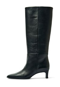 Črni usnjeni škornji do kolen s koničastim prstom in zmernim petom. Gladek tekstura, minimalni poudarki in tesno prileganje.