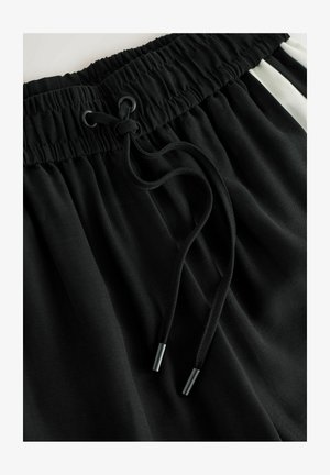 Schwarze Sportshorts mit elastischem Bund und Kordelzug, glatter Textur und kontrastierenden weißen Seitenstreifen.