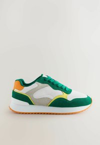 Adidași verzi și albi, realizati din suede și piele, cu o talpă albă masivă și accente portocalii, galbene și gri.