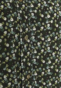Tessuto a fantasia floreale in nero, con piccoli fiori bianchi e blu. Dettagli con bottoni dorati lungo la parte anteriore, dal tocco morbido.