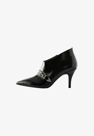 Bottine en cuir verni noir avec bout pointu, dotée d'une boucle décorative en or et d'un talon aiguille fin. Texture lisse et brillante.