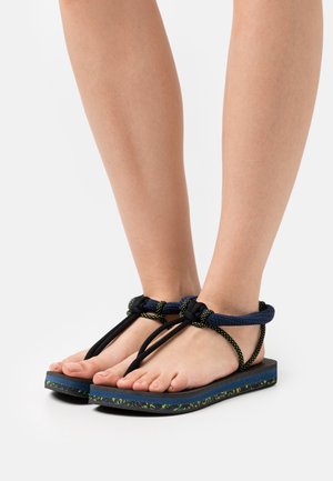 Black and blue sandals with a textured sole, featuring braided straps in dark blue and green accents, and an open toe design.