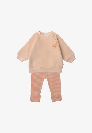 Beige Sweatshirt mit langen Ärmeln und kleinem orangefarbenem "6 AM Club"-Grafik, kombiniert mit orange-beige gestreiften, hochgekrempelten Leggings.