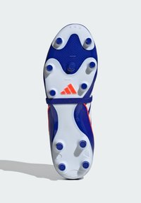 Botín de fútbol azul y blanco con acentos naranjas, que presenta una suela texturizada y tacos circulares para tracción. Marca Adidas visible.