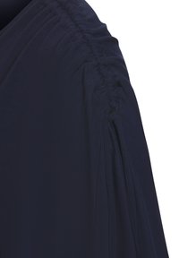 Blusa de un azul marino oscuro con textura fruncida en los hombros, tela ligera y un diseño elegante y fluido.
