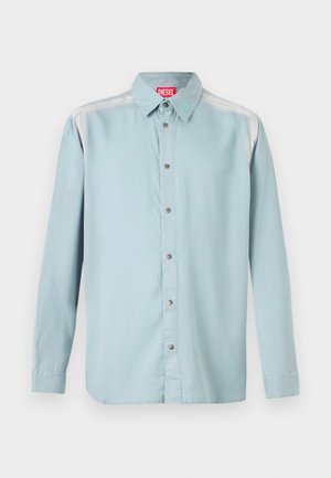 Camicia button-up azzurro chiaro con colletto standard, dotata di un'etichetta rossa, bottoni metallici e una texture di tessuto liscia.
