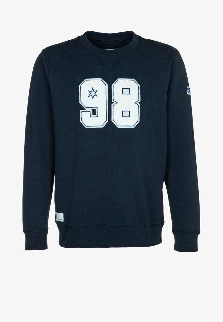 Sweat-shirt à manches longues bleu marine avec un "98" blanc et un motif étoile sur le devant, poignets côtelés et une petite écusson sur le côté.