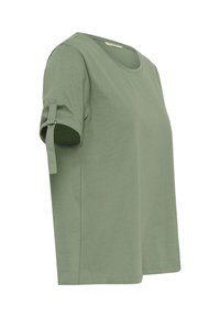 Green cotton t-shirt with a round neckline and rolled short sleeves, featuring a side tab detail for adjusting sleeve length.