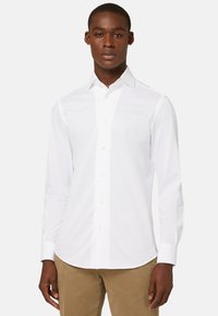 Witte lange mouwen button-up shirt met een klassieke kraag, gemaakt van gladde stof, met lichte knopen en een gebogen zoom. Draag het met beige broek.