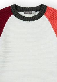 Suéter de punto con un cuerpo blanco, tejido texturizado y mangas raglán en colores burdeos, verde oscuro y coral. Cuello de canalé.