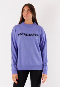Maglione in lana lilla con collo alto e vestibilità morbida. Presenta il logo nero "PATRIZIA PEPE" e una piccola grafica nera sul polsino.