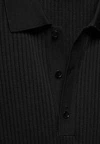 Černé žebrované polo tričko s klasickým límcem a třemi knoflíky. Textura je hladká s pravidelným vzorem svislých pruhů.