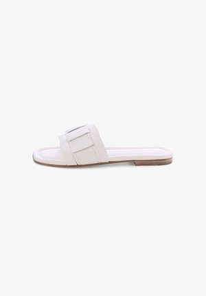 White flat slide sandal with wide strap featuring a large buckle detail and a thin brown sole.