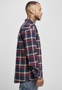 Blau-rot karierte Flanellhemd mit Knopfleiste, langen Ärmeln und normaler Passform. Der Stoff wirkt weich mit einer strukturierten Optik.