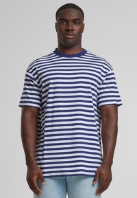 T-shirt rayé avec des bandes horizontales bleu marine et blanches, col rond et manches courtes. Fabriqué en coton avec une coupe décontractée.
