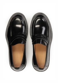 Black patent leather loafers with a stitched white accent. Features a wide strap across the vamp and a smooth, shiny finish.