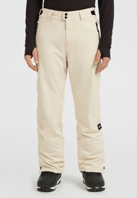 Beige sneeuwbroeken van een gladde, waterafstotende stof, met een ritszak, dubbele knopen en een verstelbare tailleband voor een veilige pasvorm.