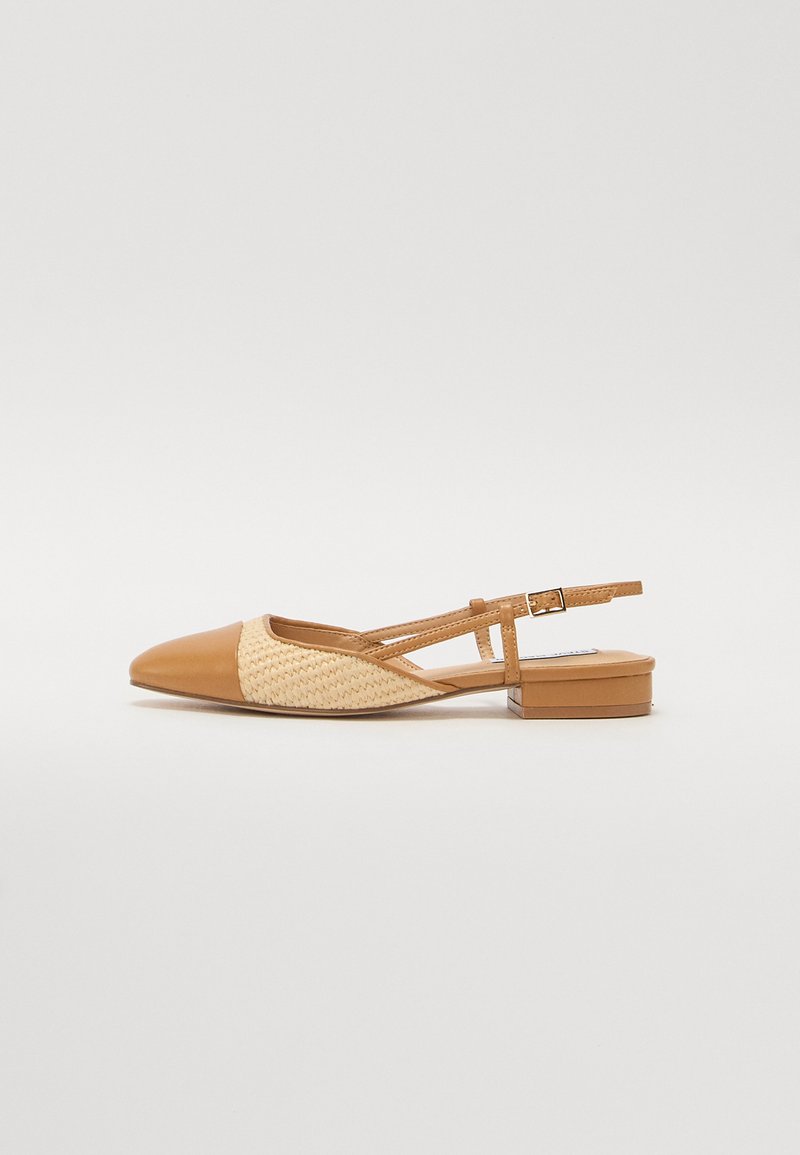 Brūns slingback apavi ar smailu pirkstu, austu salmu akcentu un zemu bloku papēdi. Iekļauj regulējamu potītes jostu, kas nodrošina piemērotību.