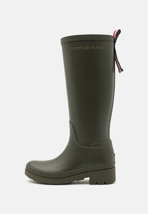 Bota de lluvia alta de goma color verde oliva con suela gruesa, lengüeta de tirador en rojo-blanco-azul y logo "Tommy Hilfiger" cerca de la parte superior.