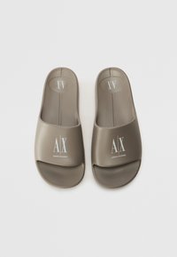 Dark gray slide sandals with a smooth, matte finish. Features an open toe, wide upper strap, and white logo detailing on the sides.