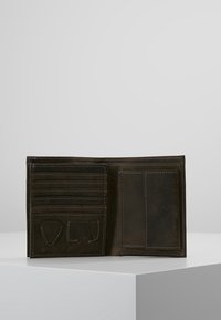 Portafoglio in pelle marrone con diversi scomparti per carte, una tasca trasparente per l'ID e due compartimenti aggiuntivi. Texture liscia con dettagli di cucitura visibili.