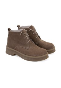 Braune Wildleder-Stiefeletten mit einer erhöhten Plateausohle, ausgestattet mit Schnürverschluss und Zuglaschen für einfachen Einstieg. Glatte Innenauskleidung.