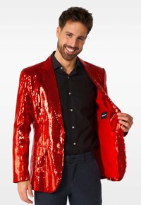 Roter Pailletten-Blazer mit glänzender Textur, zwei Knöpfen, Einzelbrusttasche und rotem Satinfutter, getragen über einem schwarzen Hemd und dunkelblauen Hosen.
