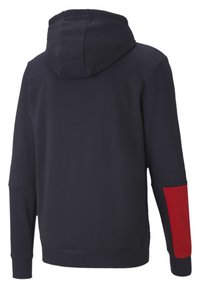 Marinblå hoodie med en röd accent på den högra ärmen, tillverkad av mjukt tyg, med dragsko på huvan och långa ärmar.