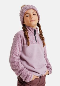 Helllila Fleece-Pullover mit gemusterten Ärmeln und einem halben Reißverschlusskragen. Kombiniert mit einer passenden gestrickten Mütze, ebenfalls helllila.