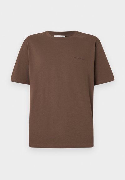 Rjava bombažna majica s krožnim izrezom, kratkimi rokavi in majhnim logotipom, natisnjenim spredaj. Ravna tekstura tkanine, sproščen kroj.