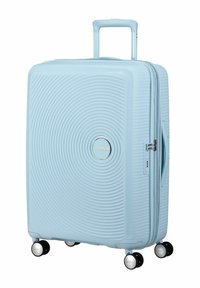 Valigia rigida di colore azzurro chiaro con design a spirale testurizzato, ruote doppie, manico estensibile e logo argentato del marchio sul davanti.