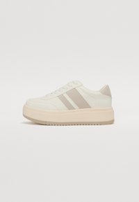 Hvite plattform-sneakers med grå semsket skinn-aksenter, avrundet tå, snøring og teksturert gummisåle. Glatte og kontrasterende materialer.