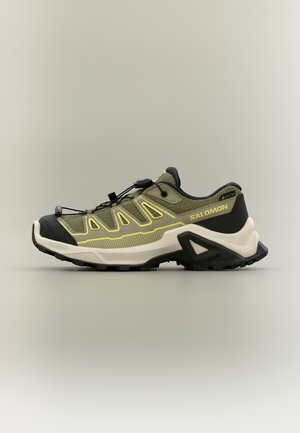 Trailrunning-Schuh in Olivgrün und Schwarz mit beiger Sohle, Schnellverschluss-Schnürsystem und Salomon-Logo an der Seite.