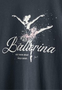 Mørkegrå t-shirt med et trykt billede af en ballerina i en pink tutu, med hvid tekst der står "Ballerina" og "Hold Dit Hoved Højt".
