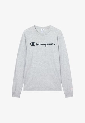 Maglietta grigia a maniche lunghe in cotone con logo nero "Champion" sul petto e piccolo logo sul polsino della manica sinistra.