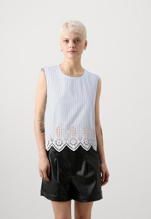 Top sans manches rayé bleu et blanc avec un ourlet en dentelle festonnée et des détails à œillets ; porté avec un short en cuir noir.
