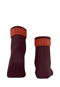 Chaussettes montant aux genoux en rouge foncé avec un poignet côtelé orange. Fabriquées en tissu, texture lisse et forme effilée.