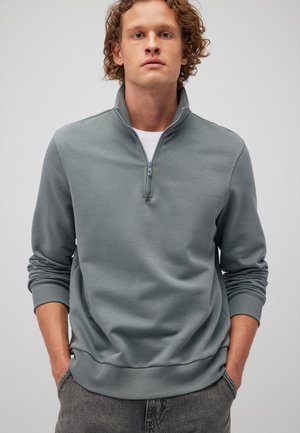 Light grey quarter-zip sweatshirt made of soft cotton blend. Features ribbed cuffs and hem, with a smooth texture and minimal design.