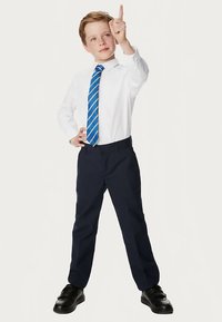 Weißes Hemd mit langen Ärmeln, blau gestreifte Krawatte, marineblaue Hose und schwarze Schuhe. Das Kind posiert mit einem erhobenen Finger und präsentiert ein gepflegtes Erscheinungsbild.