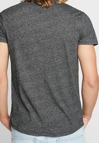 Gray short-sleeve t-shirt made from a soft, textured fabric. Features a crew neck and a fitted design with no visible logos or embellishments.