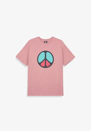 Camiseta de algodón rosa con un gran gráfico de símbolo de paz negro en turquesa y rojo. Mangas cortas, cuello redondo, corte relajado.