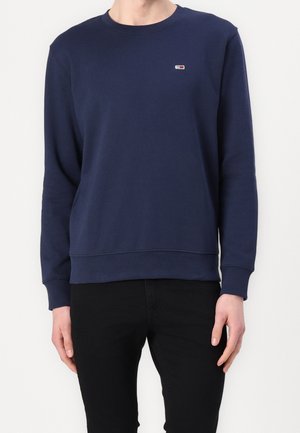 Marinblå bomulls-sweatshirt med rund hals och långa ärmar, med en liten logotyp på bröstet samt ribbad nederkant och ärmslut.