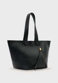 Sac cabas en cuir noir avec un design structuré, base plate, longues anses et une poche avant zippée avec des accents métalliques dorés.