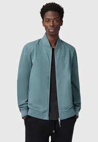 Giacca bomber verde chiaro con zip frontale, colletto e polsini a coste, due tasche laterali e ricamo del logo discreto sul petto.