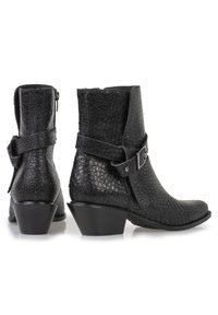 Botines negros de cuero texturizado con un patrón de reptil, con cremallera lateral y detalle de correa con hebilla. Tacón bajo.
