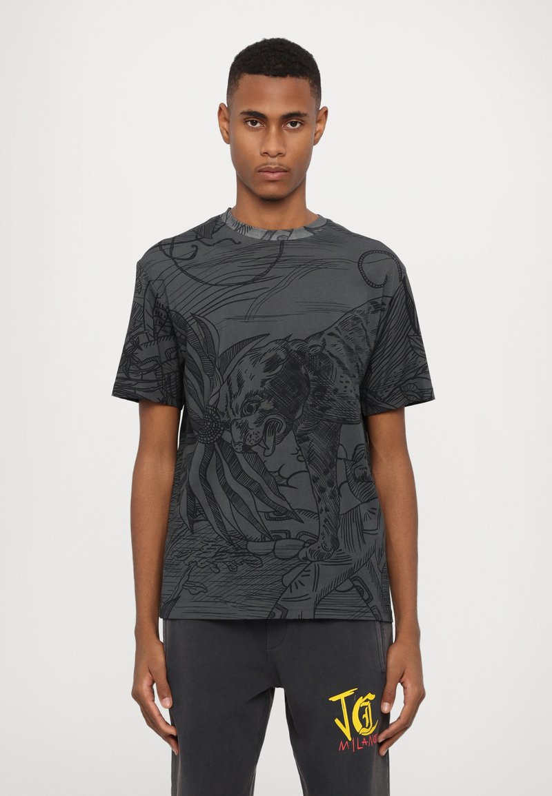 T-shirt graphique noir présentant un dessin linéaire détaillé d'un léopard et des motifs abstraits. Col rond, manches courtes, fabriqué en tissu doux.