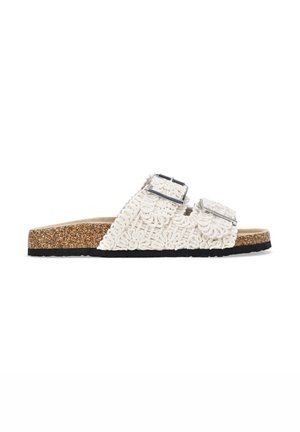 Sandalias blancas de tejido con dos correas ajustables de hebilla plateada, planta de corcho y suela de goma negra. Textura decorativa de cuerda en las correas.